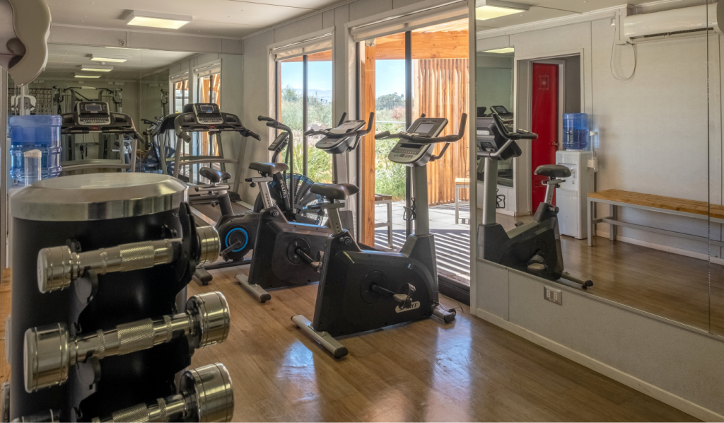 Gimnasio equipado en el hotel Village Calama con máquinas modernas y funcionales.